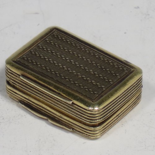 An Antique Georgian Sterling silver and gold-gilt vinaigrette, having engine-turned decoration, reeded sides, a gold-gilt interior, and a hand-pierced grill with floral work. Made by Thomas Shaw of Birmingham in 1829. The dimensions of this fine hand-made silver vinaigrette are length 2.5 cms (1 inch), width 2 cm (0.6 inches), and depth 1 cm (0.4 inches).