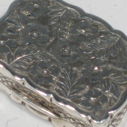 Antique Victorian sterling silver vinaigrette, having a rectangular shaped body with hand-engraved floral decoration (with roses and ferns), a hinged lid with vacant cartouche, and a gold-gilt interior with hinged hand-pierced and chased grill. Made by George Unite of Birmingham in 1838. The dimensions of this fine hand-made silver vinaigrette are length 3.5 cms (1.3 inches), and width 2.5 cms (1 inch).