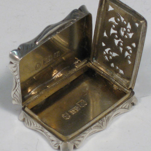 Antique Victorian sterling silver vinaigrette, having a rectangular shaped body with hand-engraved floral decoration and a vacant cartouche, a hinged lid, and a gold-gilt interior with hinged hand-pierced and chased grill. Made by Edward Smith of Birmingham in 1843. The dimensions of this fine hand-made silver vinaigrette are length 3.5 cms (1.3 inches), and width 2.5 cms (1 inch).