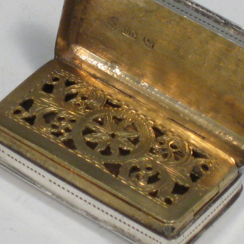 Antique Georgian sterling silver vinaigrette, having a rectangular body with hand-engraved floral decoration, a hinged lid, a gold-gilt interior with hinged sun-burst grill. Made by Lawrence & Co., of Birmingham in 1831. The dimensions of this fine hand-made silver vinaigrette are length 3.2 cms (1.25 inches), and width 1.7 cms (0.5 inches).
