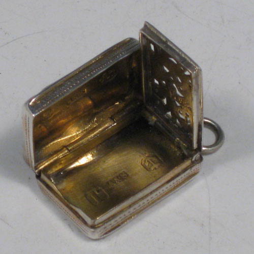 Antique Victorian sterling silver vinaigrette, having a rectangular body with with engine-engraved decoration and a vacant cartouche, a hinged lid, a gold-gilt interior with hinged hand-pierced and chased grill, and a side ring. Made by Aston & Son, of Birmingham in 1858. The dimensions of this fine hand-made silver vinaigrette are length 2 cms (0.75 inches), and width 1.5 cms (0.5 inches).