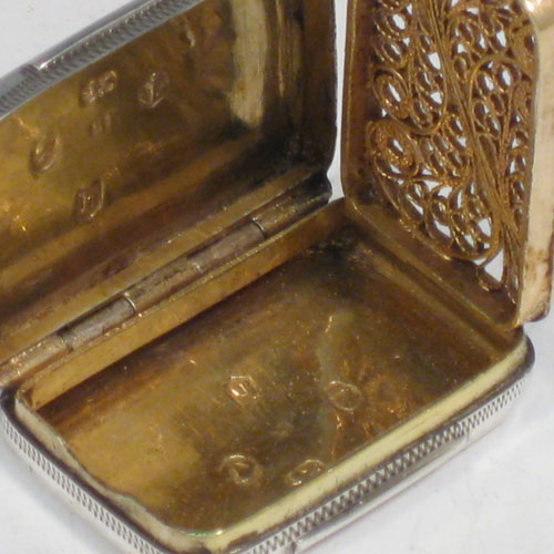 Antique Georgian sterling silver vinaigrette, having a rectangular body with hand-engraved Greek-Key decoration, a hinged lid, and a gold-gilt interior with hinged fillagree grill. Made by Samuel Pemberton of Birmingham in 1805. The dimensions of this fine hand-made silver vinaigrette are length 2.5 cms (1 inches), and width 2 cms (0.75 inches).