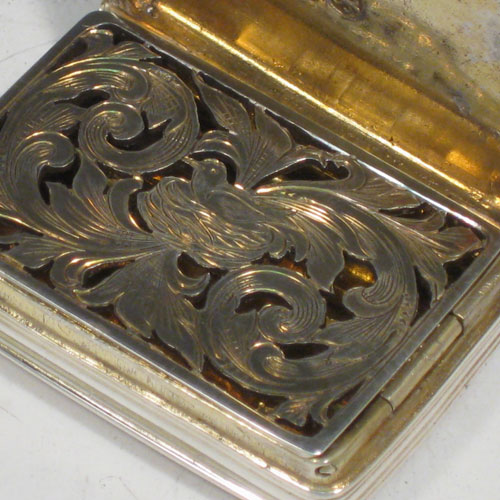 Antique Georgian sterling silver vinaigrette, having a rectangular body with hand-engraved reeded decoration and vacant cartouche, a hinged lid, a gold-gilt interior with hinged hand-pierced and chased grill with floral decoration. Made by Nathaniel Mills of Birmingham in 1828. The dimensions of this fine hand-made silver vinaigrette are length 4 cms (1.5 inches), and width 2.5 cms (1 inch).