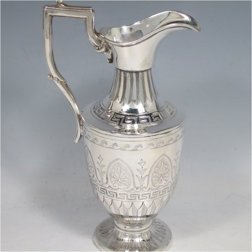 An Antique Victorian Sterling Silver water jug, in a Neoclassical Georgian style, having a hand-engraved body with Greek-Key and floral decoration, a plain spout and a scroll handle with thumb-piece, all sitting on a pedestal foot. Made by James Dixon & Sons of Sheffield in 1871. The dimensions of this fine hand-made antique silver water jug are height 20 cms (8 inches), length 12 cms (4.75 inches), and it weighs approx. 280g (9 troy ounces). Please note that this silver water jugs size would be perfect for serving two people.   