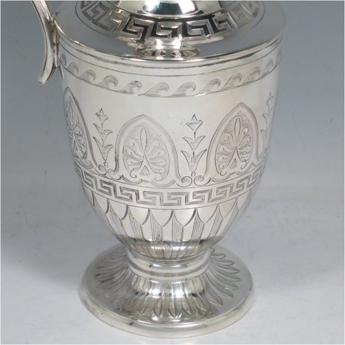An Antique Victorian Sterling Silver water jug, in a Neoclassical Georgian style, having a hand-engraved body with Greek-Key and floral decoration, a plain spout and a scroll handle with thumb-piece, all sitting on a pedestal foot. Made by James Dixon & Sons of Sheffield in 1871. The dimensions of this fine hand-made antique silver water jug are height 20 cms (8 inches), length 12 cms (4.75 inches), and it weighs approx. 280g (9 troy ounces). Please note that this silver water jugs size would be perfect for serving two people.