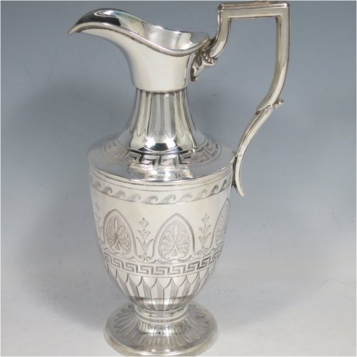 An Antique Victorian Sterling Silver water jug, in a Neoclassical Georgian style, having a hand-engraved body with Greek-Key and floral decoration, a plain spout and a scroll handle with thumb-piece, all sitting on a pedestal foot. Made by James Dixon & Sons of Sheffield in 1871. The dimensions of this fine hand-made antique silver water jug are height 20 cms (8 inches), length 12 cms (4.75 inches), and it weighs approx. 280g (9 troy ounces). Please note that this silver water jugs size would be perfect for serving two people.