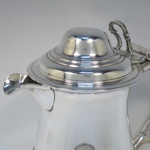 A very handsome Antique Georgian Sterling Silver water or beer jug, having a plain round bellied body with an applied central reeded girdle, a plain pouring spout, a scroll handle with heart-shaped terminal, a hinged domed lid with pierced thumb-piece, and sitting on a plain round stepped pedestal foot. Made by John Payne of London in 1754. The dimensions of this fine hand-made antique silver beer or water jug are height 21 cms (8.5 inches), length 21 cms (8.5 inches), and it weighs approx. 870g (28 troy ounces).