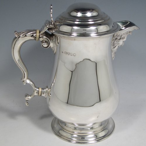 Antique Victorian sterling silver water or beer jug, having a plain round baluster body, with insulated scroll handle, a hinged domed lid with hand-pierced thumb-piece, a spout with hand-chased Bacchus face, a gold-gilt interior, and all sitting on a collet foot. Made by Robert Hennell of London in 1871. The dimensions of this fine hand-made silver beer or water jug are height 21 cms (8.25 inches), length 20 cms (8 inches), and it weighs approx. 777g (25 troy ounces).