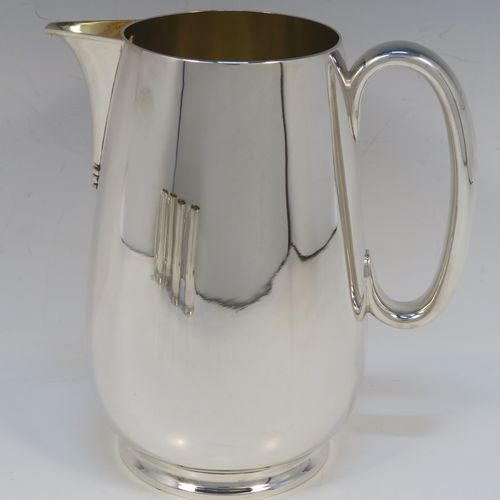 A very handsome Antique Edwardian Silver-Plated water jug with four mugs, in a very plain style, having round bellied bodies with tapering sides, a sparrow-beak spout, scroll side-handles, gold-gilt interiors, and all sitting on collet feet. This antique silver-plated water jug serving set was made in ca. 1900 by Martin Hall and Co., of Sheffield. The dimensions of this fine hand-made silver-plated water jug are height 20 cms (8 inches), and height of mugs are 10 cms (4 inches).