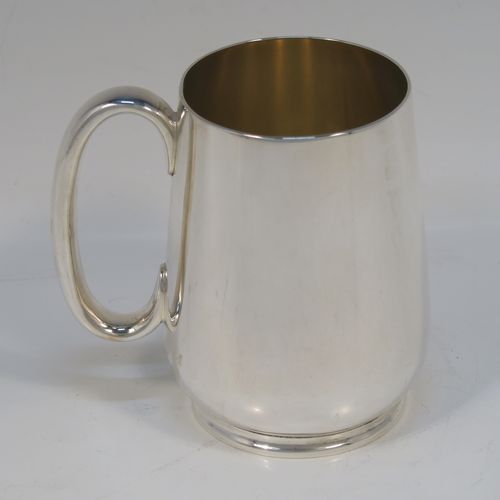 A very handsome Antique Edwardian Silver-Plated water jug with four mugs, in a very plain style, having round bellied bodies with tapering sides, a sparrow-beak spout, scroll side-handles, gold-gilt interiors, and all sitting on collet feet. This antique silver-plated water jug serving set was made in ca. 1900 by Martin Hall and Co., of Sheffield. The dimensions of this fine hand-made silver-plated water jug are height 20 cms (8 inches), and height of mugs are 10 cms (4 inches).