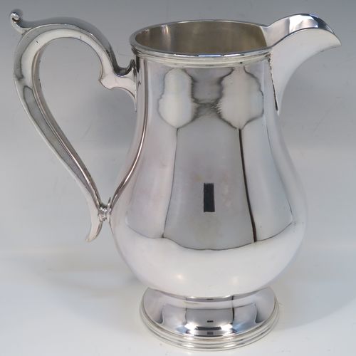 A very handsome and large Silver Plated water jug, in a George I beer jug style, having a plain round bellied body, a sparrow-beak spout, a scroll handle, and sitting on a pedestal foot. This elegant silver-plated water or beer jug was made in ca. 1930. The dimensions of this fine hand-made silver plated water jug are height 23 cms (9 inches), and length 22 cms (8.5 inches).   