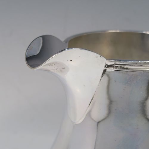 A very handsome and large Silver Plated water jug, in a George I beer jug style, having a plain round bellied body, a sparrow-beak spout, a scroll handle, and sitting on a pedestal foot. This elegant silver-plated water or beer jug was made in ca. 1930. The dimensions of this fine hand-made silver plated water jug are height 23 cms (9 inches), and length 22 cms (8.5 inches).   