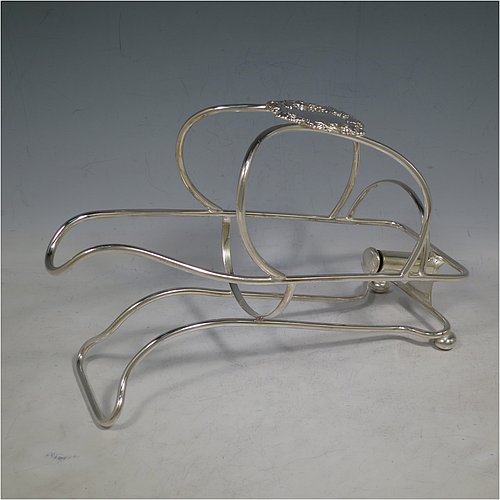 An Antique Victorian Silver Plated wine bottle cradle or holder, having a wire-work body with a cast wine-label style cartouche attached to the handle, and sitting on a base with two cushion feet. Made in Sheffield in ca. 1880. The dimensions of this fine hand-made antique silver wine bottle holder or cradle are length 24 cms (9.5 inches), width 10 cms (4 inches), and height 16.5 cms (6.5 inches). Please note that this wine bottle cradle will accept a standard 75cl, (bottle shown for display purposes only).    