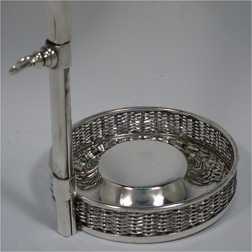 An Antique Victorian Silver Plated wine bottle cradle or holder, having a round straight-sided base with basket-weave hand-pierced decoration, a plain sliding scroll handle with matching basket weave neck and retaining screw. Made by J. and B. of Sheffield in ca. 1870. The dimensions of this fine hand-made antique silver-plated wine bottle holder or cradle are height 26 cms (10 inches), or 33 cms (13 inches) extended, and diameter of base 11.5 cms (4.5 inches). Please note that this wine bottle cradle or holder will accept a 75cl bottle, (bottle shown for display purposes only).