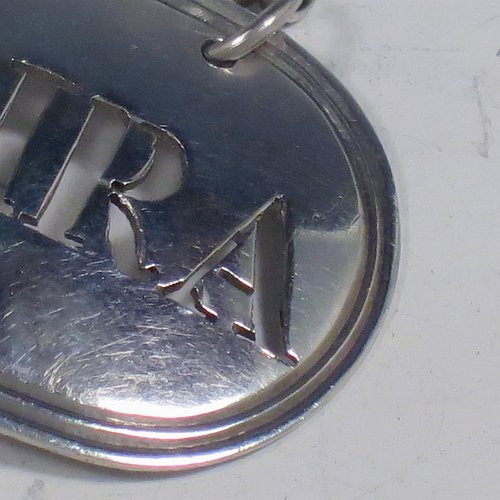 A rare 18th century Antique Georgian Sterling Silver wine decanter label, having a plain elongated oval shaped body, with a reeded border, hand-pierced for Madeira, and with its original bottle chain. Made by Thomas Phipps & Edward Robinson of London 1795. The dimensions of this fine hand-made antique silver decanter wine label are height 2.5 cms (1 inch), length 4.5 cms (1.75 inches), and it weighs approx. 10g (0.32 troy ounces).
