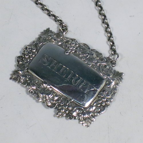 An Antique Victorian Sterling Silver wine decanter label, having a shaped rectangular body, with applied grape and vine-leaf border, hand-engraved for Sherry, and with its original bottle chain. Made by Joseph Wilmore of Birmingham in 1840. The dimensions of this fine hand-made antique silver decanter wine label are height 3.5 cms (1.3 inches), length 4.5 cms (1.75 inches), and it weighs approx. 12g (0.38 troy ounces).