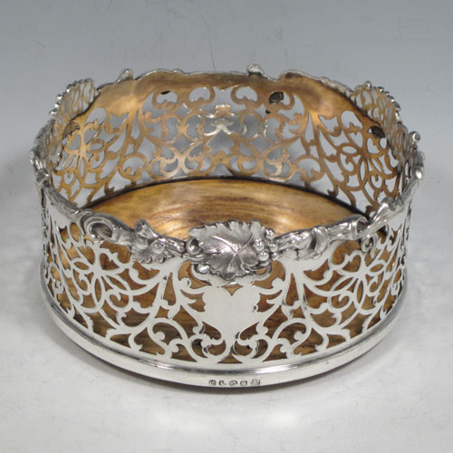 Antique Victorian silver plated pair of large wine bottle coasters, having straight sides with hand-pierced floral decoration, applied cast grape-vine borders, and wood-turned bases with silver buttons. Made by Martin Hall & Co., in ca. 1860. The dimensions of these fine hand-made silver-plated wine coasters are diameter 14 cms (5.5 inches), and height 7 cms (2.75 inches).