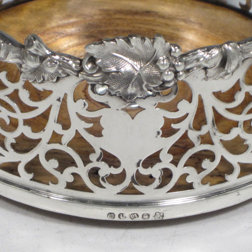 Antique Victorian silver plated pair of large wine bottle coasters, having straight sides with hand-pierced floral decoration, applied cast grape-vine borders, and wood-turned bases with silver buttons. Made by Martin Hall & Co., in ca. 1860. The dimensions of these fine hand-made silver-plated wine coasters are diameter 14 cms (5.5 inches), and height 7 cms (2.75 inches).