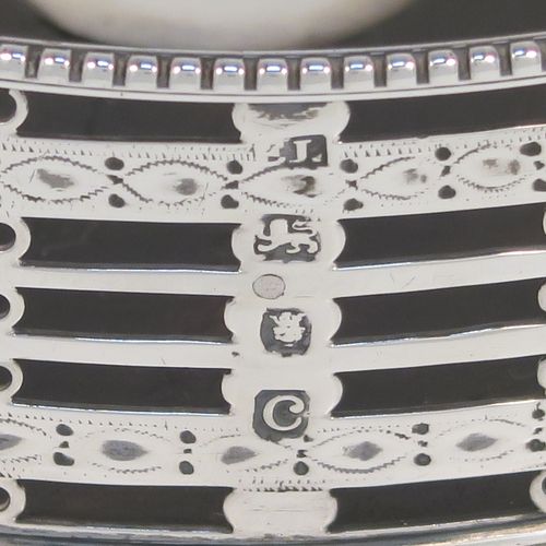 A beautiful and large Antique Georgian Neoclassical style Sterling Silver wine bottle table coaster, having a round hand-pierced body with banded geometrical decoration, together with an applied bead-edged border, and a wood-turned base with silver button. This elegant antique silver wine bottle coaster was made by Edward Lowe of London in 1778. The dimensions of this fine hand-made antique silver wine bottle coaster are diameter 14.5 cms (5.75 inches), and height 4.5 cms (1.75 inches).