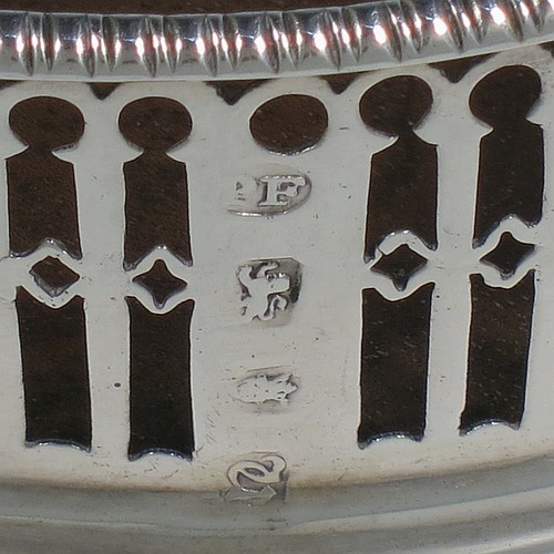 A very pretty Antique Georgian Sterling Silver pair of Neoclassical style wine coasters, having hand-pierced walls, applied gadroon borders, and plain oak bases. Made by Philip Freeman of London in 1775. The dimensions of this fine hand-made antique pair of silver wine bottle coasters are diameter 12 cms (4.75 inches), and height 3.5 cms (1.3 inches).   