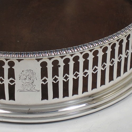 A very pretty Antique Georgian Sterling Silver pair of Neoclassical style wine coasters, having hand-pierced walls, applied gadroon borders, and plain oak bases. Made by Philip Freeman of London in 1775. The dimensions of this fine hand-made antique pair of silver wine bottle coasters are diameter 12 cms (4.75 inches), and height 3.5 cms (1.3 inches).   