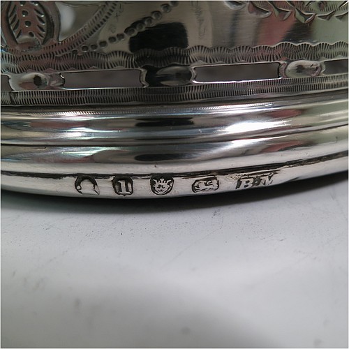 A very pretty Antique Georgian Sterling Silver pair of Neoclassical style wine coasters, having hand-pierced walls with hand-engraved neoclassical decoration, applied bead-edge borders, and oak hand-turned bases. Made by Benjamin Mountigue of London in 1786. The dimensions of this fine hand-made antique pair of neoclassical style silver wine bottle coasters are diameter 11.5 cms (4.5 inches), and height 4 cms (1.5 inches).