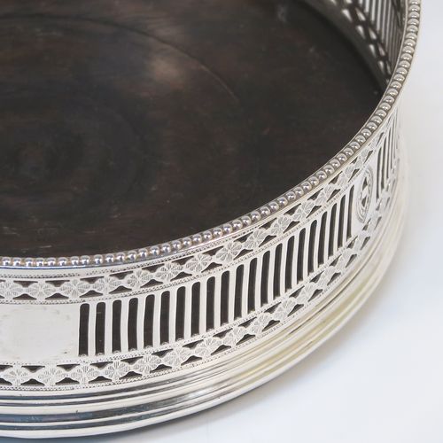 A very handsome Antique Georgian Old Sheffield Plated pair of Neoclassical style wine coasters, having hand-pierced walls, applied bead-edged borders, and plain oak-turned bases. These beautiful antique silver-plated bottle coasters were made in ca. 1780. The dimensions of this fine hand-made antique pair of Old Sheffield Plated silver wine bottle coasters are diameter 13 cms (5.25 inches), and height 4.5 cms (1.75 inches).