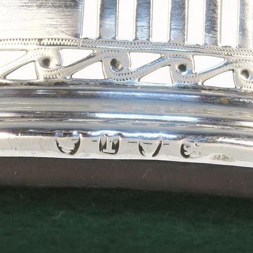 A very pretty Antique Georgian Neoclassical style Sterling Silver wine bottle table coaster, having a round hand-pierced body with geometrical and tureen style decoration, together with an applied bead-edged top border, and an wood-turned base. This beautiful antique silver wine bottle coaster was made in London in 1786. The dimensions of this fine hand-made antique silver wine bottle coaster are diameter 12 cms (4.75 inches), and height 3.5 cms (1.3 inches).
