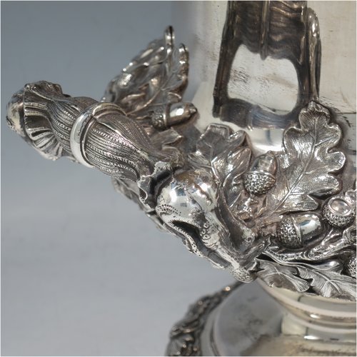 An Antique Georgian Old Sheffield plated wine cooler, in the Campagna style, with cast grape & vine borders, a pair of cast handles, and an applied oak acorn & leaf band running round the body. All with original interior and cover. Made in ca. 1825. The dimensions of this fine hand-made antique Old Sheffield wine cooler are height 29 cms (11.5 inches), width across handles 25 cms (9.75 inches). Please note that this item has an original crested inlet cartouche.