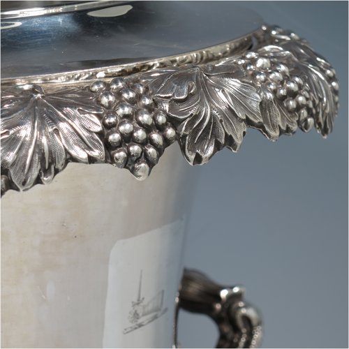 An Antique Georgian Old Sheffield plated wine cooler, in the Campagna style, with cast grape & vine borders, a pair of cast handles, and an applied oak acorn & leaf band running round the body. All with original interior and cover. Made in ca. 1825. The dimensions of this fine hand-made antique Old Sheffield wine cooler are height 29 cms (11.5 inches), width across handles 25 cms (9.75 inches). Please note that this item has an original crested inlet cartouche.