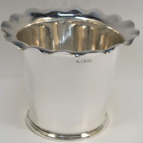 A very elegant pair of Antique Edwardian Sterling Silver wine bottle coolers, having plain round bodies with tapering sides and wavey-edged top borders, and sitting on collet feet. These elegant antique silver wine bottle coolers were made by Goldsmiths and Silversmiths of London in 1903. The dimensions of this fine pair of hand-made antique silver wine coolers are height 15 cms (6 inches), diameter at top 20 cms (8 inches), and they weigh a total of 1,210g (39 toy ounces).