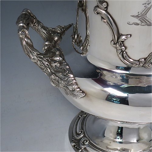 An Antique Georgian Old Sheffield plated wine cooler, in the Campagna style, with cast floral borders, a pair of cast anthemion leaf handles, and applied scroll cartouches either side. All with original interior and cover. Made in ca. 1835. The dimensions of this fine hand-made antique Old Sheffield plated wine cooler are height 30.5 cms (12 inches), width across handles 26 cms (10.25inches). Please note that this item is crested on one side.