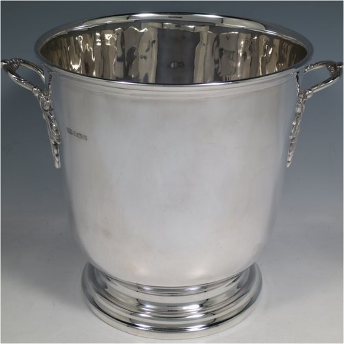 A Sterling Silver wine bottle cooler / trophy cup, having a plain round baluster body, with two cast handles with grape-vine decoration, and sitting on a collet foot. Made by Roberts & Belk of Sheffield in 1982. The dimensions of this fine hand-made silver wine cooler are height 19 cms (7.5 inches), and it weighs approx. 1,193g (38.5 troy ounces)   
