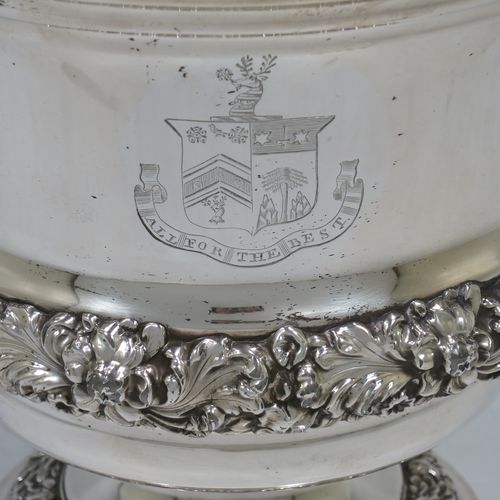 A very handsome Antique Georgian Old Sheffield plated wine cooler, in the Campagna style, with cast gadroon, scroll, and floral borders, a pair of cast side-handles, with original interior and cover, and all sitting on a pedestal foot. Made in ca. 1825. The dimensions of this fine hand-made antique Old Sheffield wine cooler are height 24.5 cms (9.75 inches), width across handles 21 cms (8.25 inches). Please note that this item is crested.
