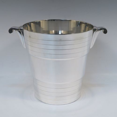 A very elegant Art Deco style Silver Plated wine bottle cooler, having a plain round body with tapering sides, with two bands of hand-engraved reeded decoration, and two cast side-handles, all sitting on a flat base. This beautiful Art Deco silver-plated wine cooler was made in ca. 1930. The dimensions of this fine hand-made silver-plated Art Deco wine cooler are height 20 cms (8 inches), and diameter at lip 19 cms (7.5 inches). Please note that this will easily hold a magnum size bottle.