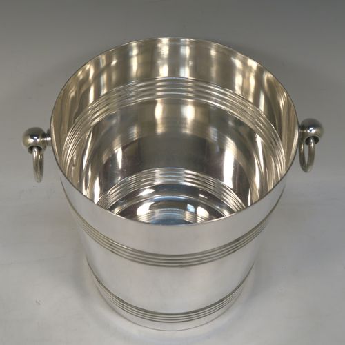 A very handsome Antique French Silver Plated wine bottle cooler, having a plain round body with tapering sides, with two bands of hand-engraved reeded decoration, and two cast ring side-handles, all sitting on a flat base. Made in ca. 1930 by the French silversmith Christophle. The dimensions of this fine hand-made antique silver-plated wine cooler are height 20 cms (8 inches), and diameter at lip 19 cms (7.5 inches). Please note that this will easily hold a magnum size bottle.  