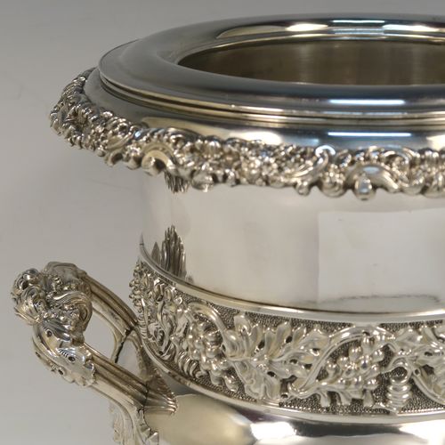 A very handsome Antique Georgian Old Sheffield plated wine cooler, in the Campagna style, with cast gadroon, scroll, and floral borders, a pair of cast side-handles, with a central applied band of grape-vine work, with its original tin-backed interior liner and cover, and all sitting on a pedestal foot. This beautiful antique Old Sheffield plated wine cooler was made in ca. 1825. The dimensions of this fine hand-made antique Old Sheffield wine cooler are height 23 cms (9 inches), and width across handles 26 cms (10.25 inches).