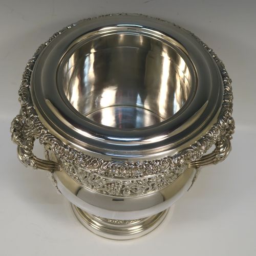 A very handsome Antique Georgian Old Sheffield plated wine cooler, in the Campagna style, with cast gadroon, scroll, and floral borders, a pair of cast side-handles, with a central applied band of grape-vine work, with its original tin-backed interior liner and cover, and all sitting on a pedestal foot. This beautiful antique Old Sheffield plated wine cooler was made in ca. 1825. The dimensions of this fine hand-made antique Old Sheffield wine cooler are height 23 cms (9 inches), and width across handles 26 cms (10.25 inches).