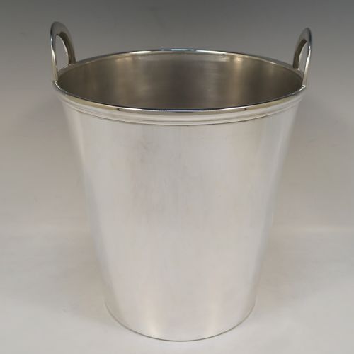 A large and very elegant Art Deco style Silver Plated wine bottle cooler, having a plain round body with tapering sides, and two cast loop side-handles, all sitting on a flat base. This beautiful silver-plated wine cooler was made in ca. 1930. The dimensions of this fine hand-made silver-plated Art Deco wine cooler are height 27 cms (10.5 inches), and diameter at lip 22 cms (8.75 inches). Please note that this will easily hold two normal size wine  bottles.  