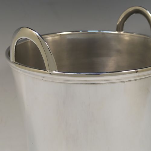 A large and very elegant Art Deco style Silver Plated wine bottle cooler, having a plain round body with tapering sides, and two cast loop side-handles, all sitting on a flat base. This beautiful silver-plated wine cooler was made in ca. 1930. The dimensions of this fine hand-made silver-plated Art Deco wine cooler are height 27 cms (10.5 inches), and diameter at lip 22 cms (8.75 inches). Please note that this will easily hold two normal size wine bottles.