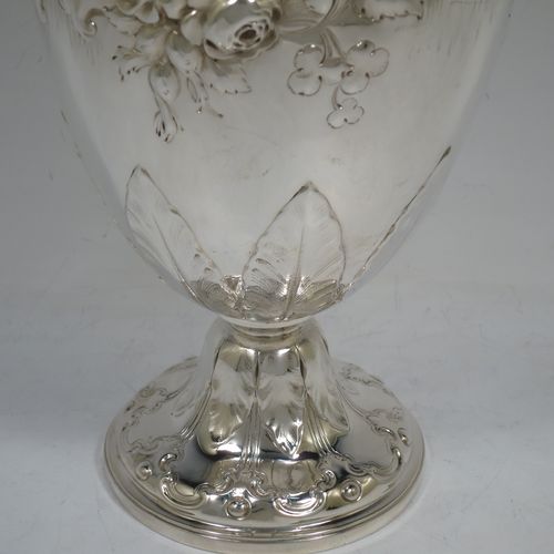 A beautiful Antique Victorian Sterling Silver wine ewer, having an amphora style round bellied body, with hand-chased floral and scroll decoration, a hinged lid with cast finial, an insulated scroll handle, and all sitting on a pedestal foot. This handsome antique silver ewer was made by the Barnard Brothers of London in 1849. The dimensions of this fine hand-made antique silver wine ewer are height 35 cms (13.5 inches), length 16.5 cms (6.5 inches), and it weighs approx. 868g (28 troy ounces).