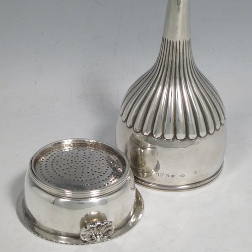 Antique Georgian sterling silver wine decanting funnel, having a round body with hand-chased half-fluted decoration, and a pull out strainer with a shell clip and gadroon border. Made by Alexander Field of London in 1816. The dimensions of this fine hand-made silver wine decanting funnel are height 15 cms (6 inches), diameter of cup 8.5 cms (3.25 inches), and it weighs approx. 117g (3.7 troy ounces).