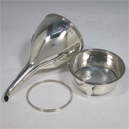 An Antique Georgian Sterling Silver wine decanting funnel, having a round body with applied reeded border and funnel struts (that allow proper aeration when decanting), a pull out strainer with a shaped clip, and an original muslin ring. Made by Alexander Field of London in 1801. Crested. The dimensions of this fine hand-made antique silver wine decanting funnel are height 14.5 cms (5.75 inches), diameter of cup 8 cms (3.25 inches), and it weighs approx. 155g (5 troy ounces).