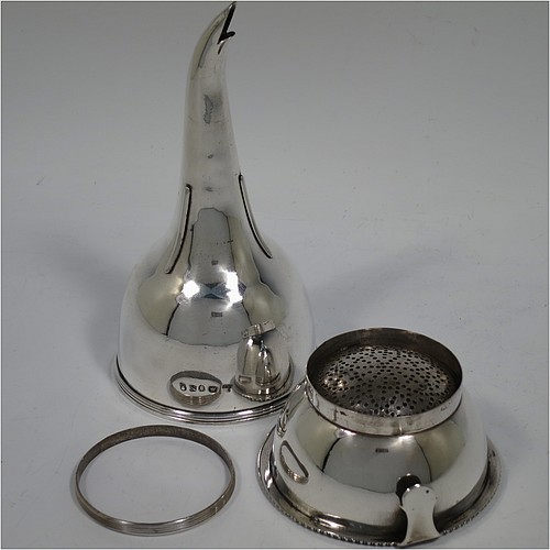 An Antique Georgian Sterling Silver wine decanting funnel, having a round body with applied reeded border and funnel struts (that allow proper aeration when decanting), a pull out hand-pierced strainer with an applied gadroon border and shaped clip, and an original muslin ring. Made by Rebecca Emes and Edward Barnard of London in 1808. The dimensions of this fine hand-made antique silver wine decanting funnel are height 15 cms (6 inches), diameter of cup 8.5 cms (3.3 inches), and it weighs approx. 162g (5.2 troy ounces).