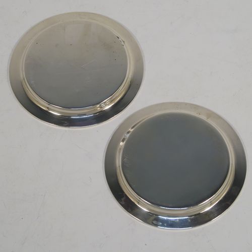 A very elegant and rare pair of Antique Georgian Sterling Silver wine decanting funnel stands or plates, having plain round bodies with applied reeded borders. This beautiful pair of wine funnel stands were made by George Reid of London in 1828. The dimensions of this fine hand-made antique silver pair of wine decanting funnel plates are outer diameter 9.5 cms (3.75 inches), inner diameter within the reeded border 8.5 cms (3.3 inches), and they weigh a total of approx. 114g (3.7 troy ounces). Please note that these items are crested.