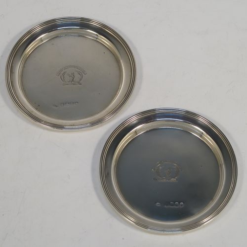 A very elegant and rare pair of Antique Georgian Sterling Silver wine decanting funnel stands or plates, having plain round bodies with applied reeded borders. This beautiful pair of wine funnel stands were made by George Reid of London in 1828. The dimensions of this fine hand-made antique silver pair of wine decanting funnel plates are outer diameter 9.5 cms (3.75 inches), inner diameter within the reeded border 8.5 cms (3.3 inches), and they weigh a total of approx. 114g (3.7 troy ounces). Please note that these items are crested.