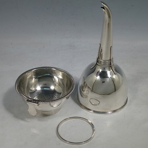 An Antique Georgian Sterling Silver wine decanting funnel, having a round body with an applied gadroon border and funnel struts (that allow proper aeration when decanting), a pull out strainer with a shaped clip, and an original muslin ring. Made by William Bateman of London in 1811. The dimensions of this fine hand-made antique silver wine decanting funnel are height 16 cms (6.3 inches), diameter of cup 8.5 cms (3.3 inches), and it weighs approx. 147g (4.7 troy ounces).