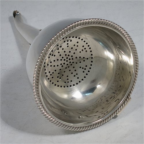 An Antique Georgian Sterling Silver wine decanting funnel, having a round body with an applied gadroon border and funnel struts (that allow proper aeration when decanting), a pull out strainer with a shaped clip, and an original muslin ring. Made by William Bateman of London in 1811. The dimensions of this fine hand-made antique silver wine decanting funnel are height 16 cms (6.3 inches), diameter of cup 8.5 cms (3.3 inches), and it weighs approx. 147g (4.7 troy ounces).