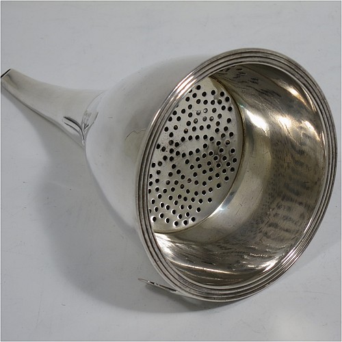 An Antique Georgian Sterling Silver wine decanting funnel, having a round plain body with applied reeded border and funnel struts (that allow proper aeration when decanting), a pull out hand-pierced strainer with an applied reeded border and shaped clip, and an original muslin ring. Made by William Bateman of London in 1820. The dimensions of this fine hand-made antique silver wine decanting funnel are height 16 cms (6.3 inches), diameter of cup 8.5 cms (3.3 inches), and it weighs approx. 158g (5 troy ounces).