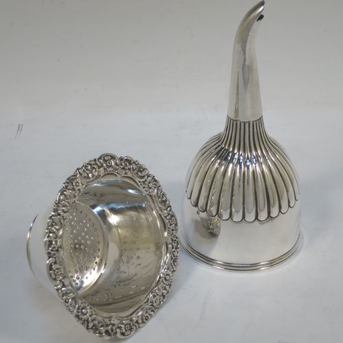 A very handsome Antique Georgian Sterling Silver wine decanting funnel, having a round body with hand-chased half-fluted decoration, and a pull out strainer with a shell clip and a shell and scroll border. Made by William Eley and William Fearn of London in 1826. The dimensions of this fine hand-made silver wine decanting funnel are height 15 cms (6 inches), diameter of cup 9.5 cms (3.75 inches), and it weighs approx. 198g (6.4 troy ounces).
